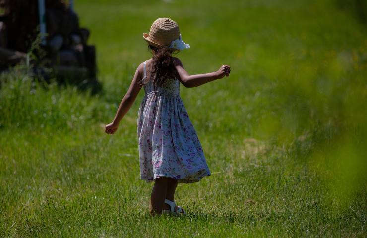 Bambina che cammina sull'erba