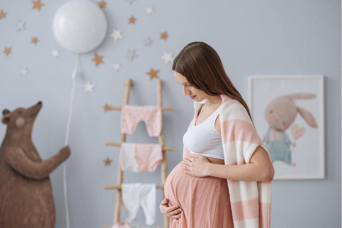 Ragazza con il pancione nella cameretta il futuro bimbo