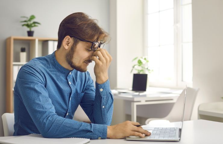 Ragazzo con fastidio alla vista durante il lavoro